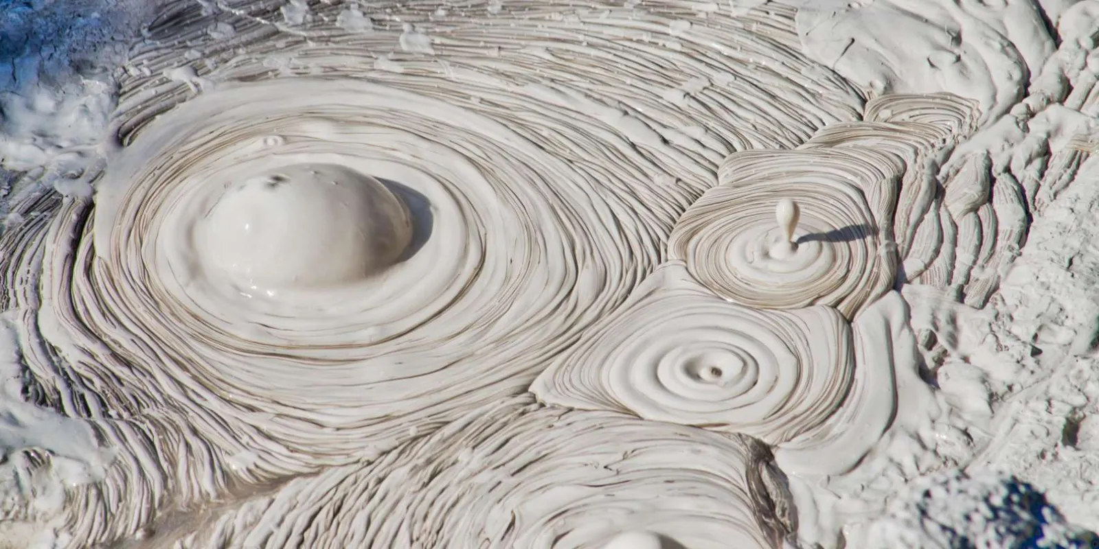 Close view of grey mud bursting in concentric rings at the Wai-O-Tapu mud pool