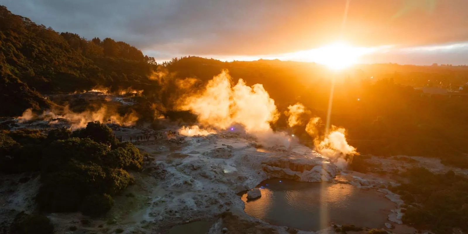 Aerial view of the Te Puia geothermal terraces steaming at sunset in Rotorua