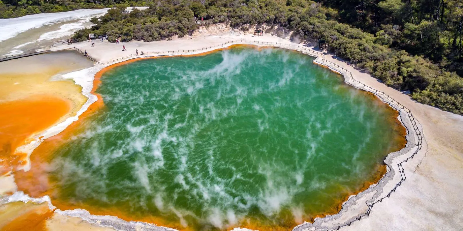 Aerial view of the Champagne Pool at Wai-O-Tapu with visitors on the boardwalk along its rim