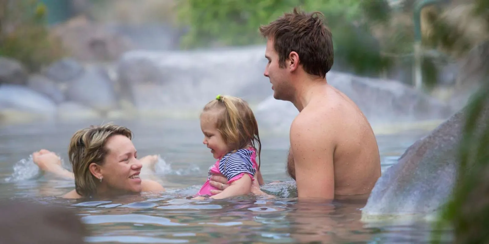 A family relaxing in a warm geothermal pool, one of the tour's afternoon add-on options