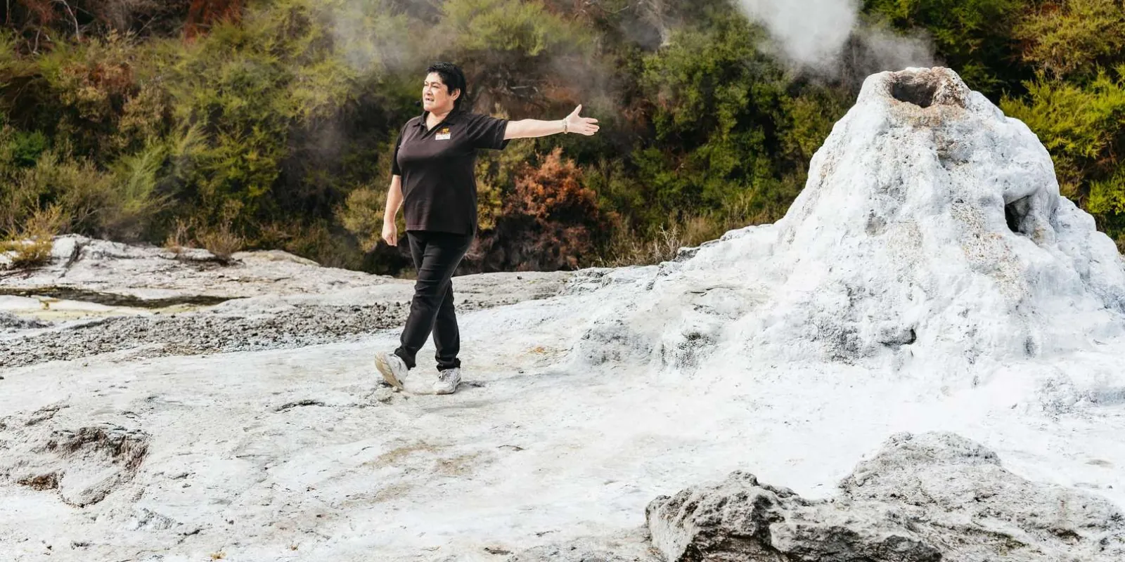 A Wai-O-Tapu staff member beside the Lady Knox Geyser cone before the 10:15 am eruption