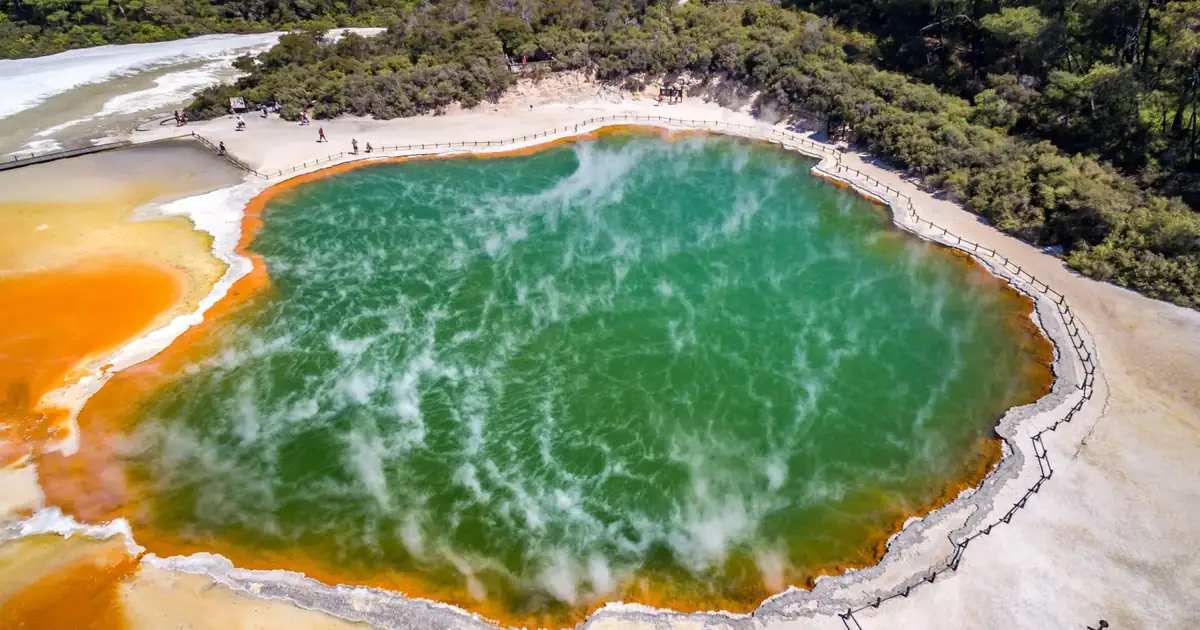 The Champagne Pool at Wai-O-Tapu from above, its orange sinter rim around green steaming water
