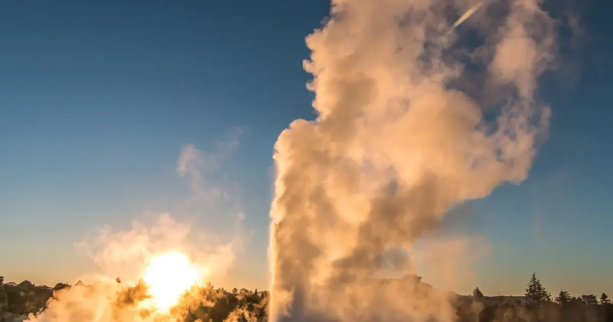 Pōhutu Geyser at Te Puia erupting into a low sun over Rotorua